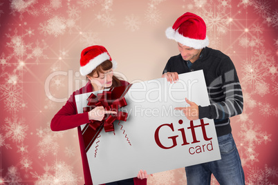 Composite image of couple holding a white sign