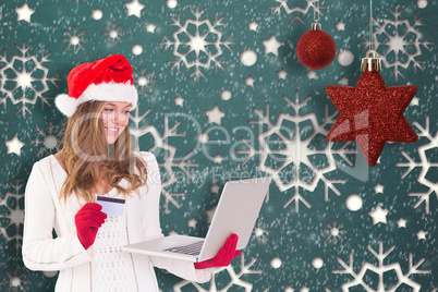 Composite image of festive blonde shopping online with laptop