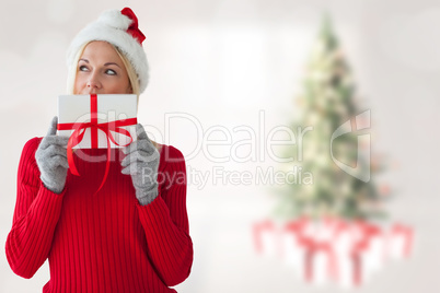 Composite image of happy festive blonde with gift