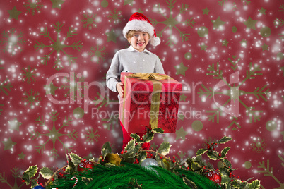 Composite image of festive boy holding gift