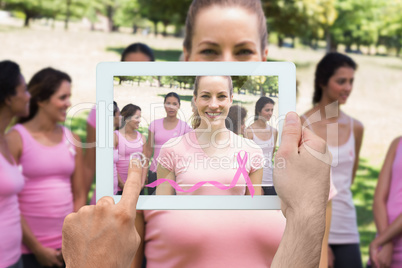 Composite image of hand holding tablet pc