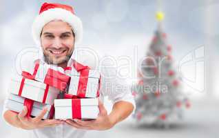 Composite image of festive man holding christmas gifts