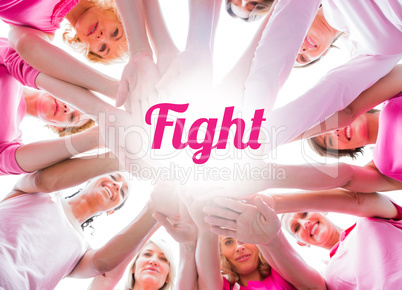 Diverse women smiling in circle wearing pink for breast cancer