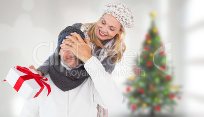 Composite image of happy winter couple with gift