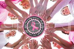 Composite image of happy women in circle wearing pink for breast
