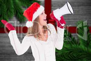 Composite image of festive blonde shouting through megaphone