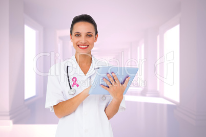 Composite image of pretty nurse using tablet pc