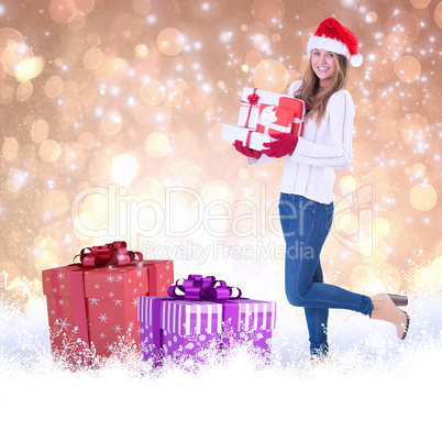 Composite image of festive blonde holding pile of gifts