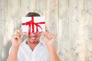 Composite image of man holding gift