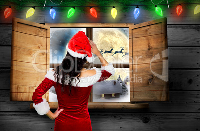 Composite image of rear view of sexy santa girl