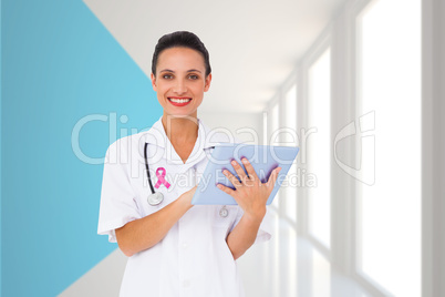 Composite image of pretty nurse using tablet pc