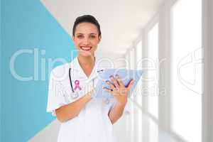 Composite image of pretty nurse using tablet pc