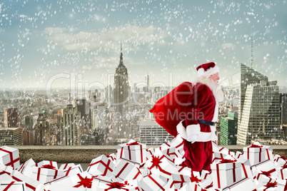 Composite image of santa walking on pile of gifts