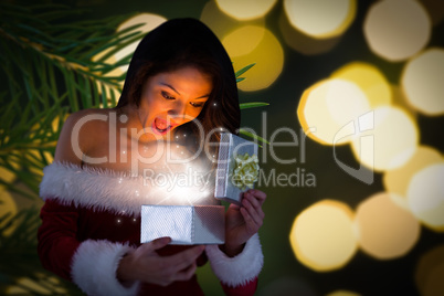 Composite image of sexy santa girl opening gift