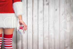 Composite image of pretty girl in santa outfit holding gift