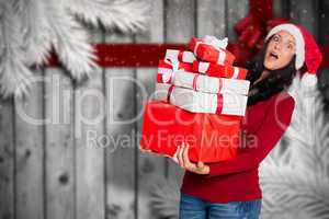 Composite image of woman holding many christmas presents