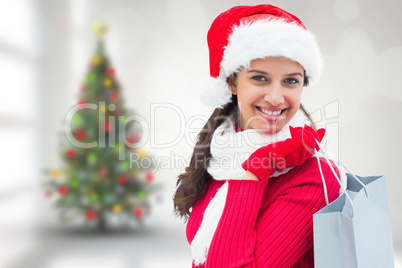 Composite image of festive brunette holding shopping bag