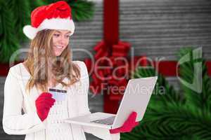 Composite image of festive blonde shopping online with laptop