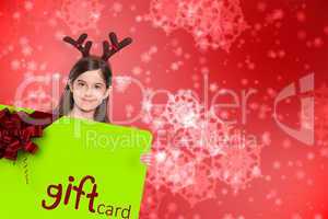 Composite image of festive little girl showing card