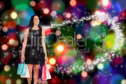 Composite image of woman walking with shopping bags