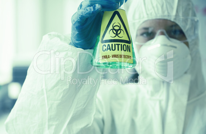 Scientist in protective suit holding beaker