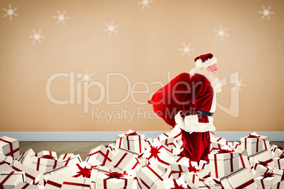 Composite image of santa walking on pile of gifts