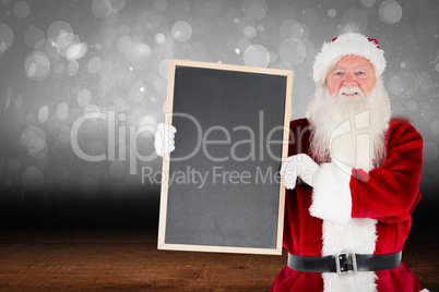 Composite image of santa claus showing blackboard