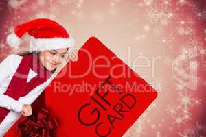 Composite image of festive little girl showing card