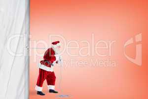 Santa claus pulling rope against orange