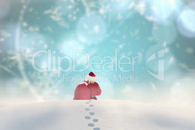 Composite image of santa walking in the snow