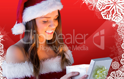 Composite image of pretty santa girl opening gift