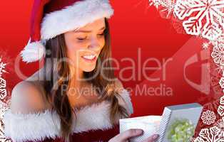 Composite image of pretty santa girl opening gift