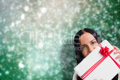 Composite image of woman holding a large present