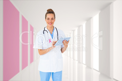 Composite image of pretty nurse using tablet pc