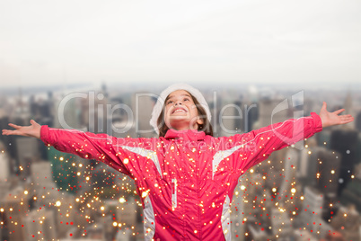 Composite image of cute girl in winter clothes with arms out