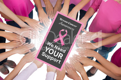 Composite image of hands joined in circle wearing pink for breas