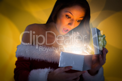 Composite image of sexy santa girl opening gift