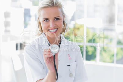 Composite image of radiant nurse showing her stethoscope