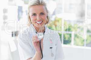 Composite image of radiant nurse showing her stethoscope
