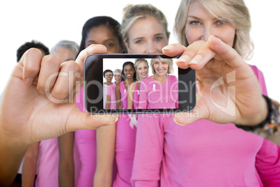 Composite image of hand holding smartphone showing