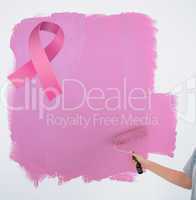 Composite image of woman painting her wall pink