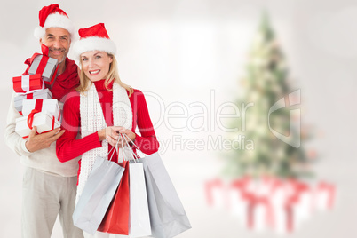 Composite image of happy festive couple with gifts and bags