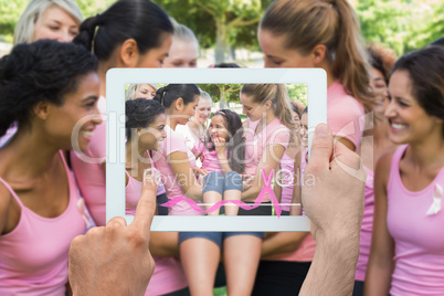 Composite image of hand holding tablet pc