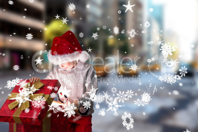 Composite image of festive boy opening gift