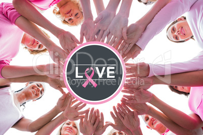 Composite image of happy women in circle wearing pink for breast