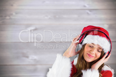 Composite image of sexy santa girl listening to music