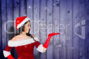 Composite image of pretty girl presenting in santa outfit