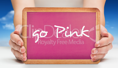 Composite image of females hands showing pink board
