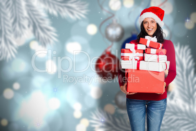 Composite image of woman holding many christmas presents