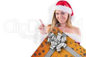 Composite image of festive blonde smiling and pointing